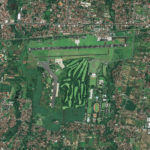 A satellite image of an airport with golf course and trees.
